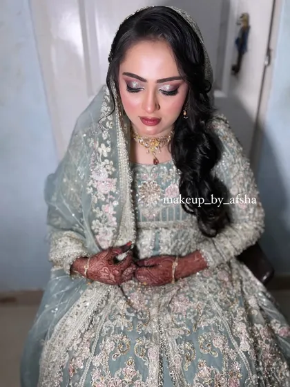 A full view of this bride in her pastel green dress. The makeup is soft and shimmery, perfect for an evening reception.