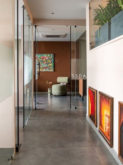 The corridor in our office, with glass walls that promote a sense of openness and transparency. The wood-paneled wall and colorful artwork add warmth and character.