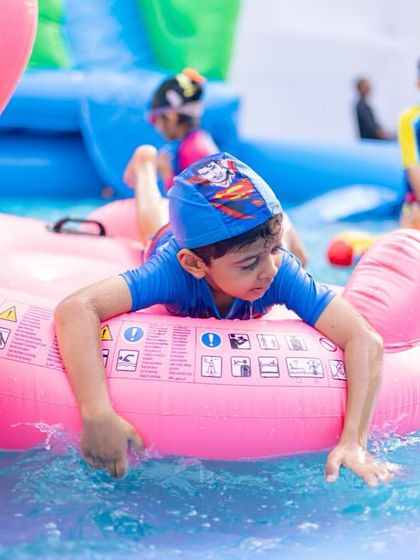 A young guest enjoys a ride on a giant pink flamingo float in the pool. I make sure to have plenty of fun, colorful floats for the kids to play with.