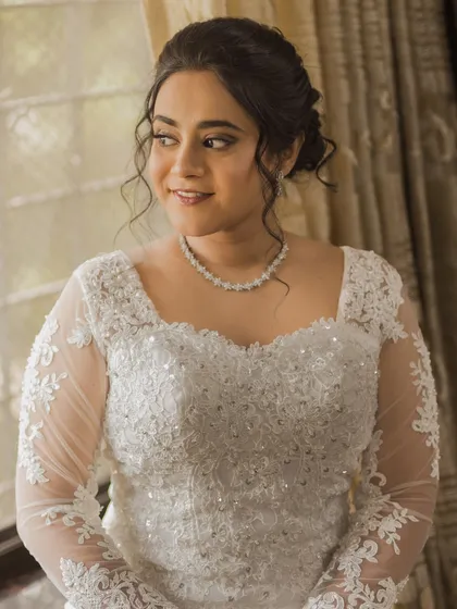 A lovely portrait of Steffi by the window. The natural light highlights her soft makeup and the intricate lace details of her gown.