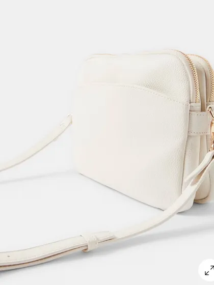 Another angle of the off-white crossbody, showing the texture of the material and the adjustable strap.
