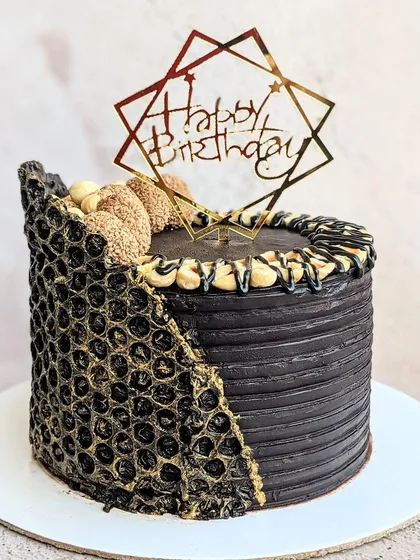 A decadent and modern Ferrero Rocher cake for a 16th birthday. I used a bubble wrap mold to create the unique gold-dusted chocolate collar, combining rich chocolate flavor with an edgy, textured design.