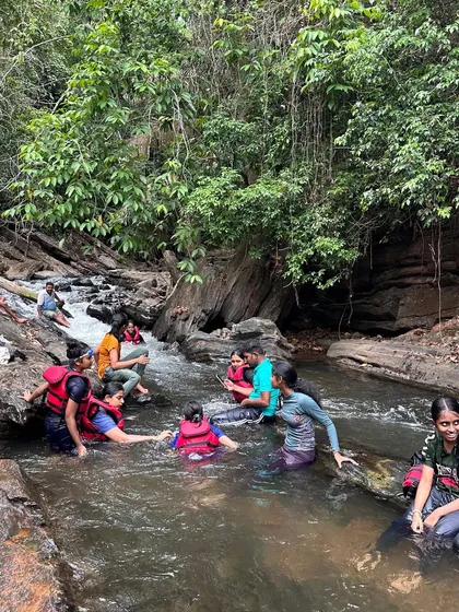 Campers relax on the rocks and in the water of a beautiful stream, fully immersed in the wilderness of Ulavi.