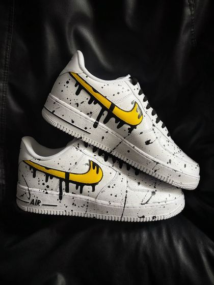 The other shoe in the pair, featuring a yellow dripping swoosh with the same splatter effect.