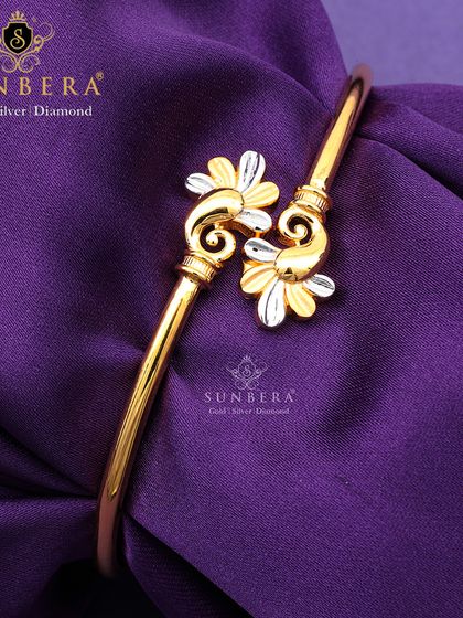 A beautiful gold bracelet with two-tone flower motifs. The intricate detailing and elegant design make it a standout piece for special occasions.