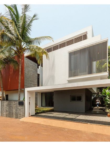 The entrance to the "Solid | Void | Solid House" is sheltered by a cantilevered volume, creating a welcoming and protected transition into the home.