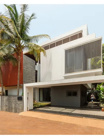 The entrance to the "Solid | Void | Solid House" is sheltered by a cantilevered volume, creating a welcoming and protected transition into the home.