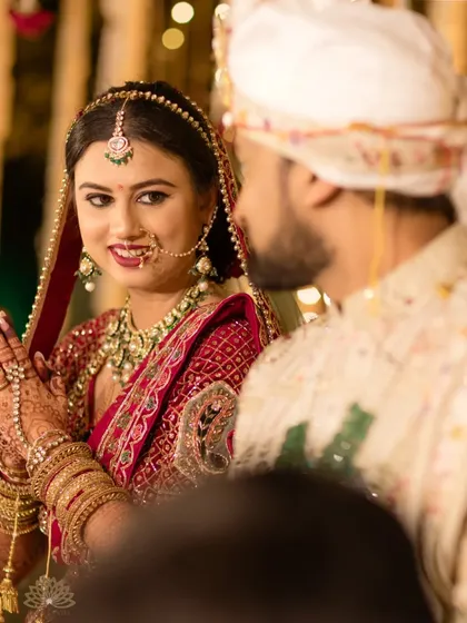 A sweet moment between the bride and groom. The bride's hands, folded in 'namaste', showcase the beautiful back-of-hand mehndi design.