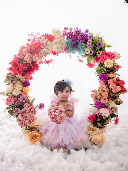 This little one, dressed in a lovely pastel dress, holds a heart-shaped bouquet in our dreamy floral ring setup.