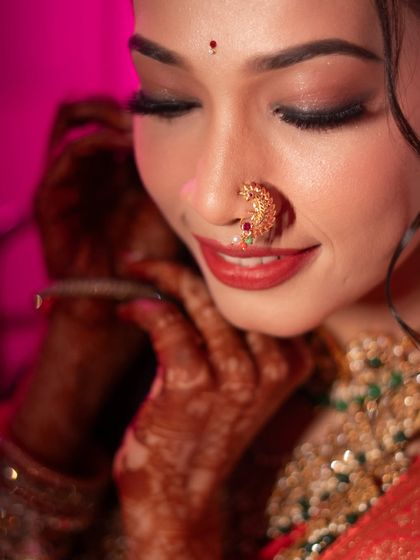 A serene portrait of a Maharashtrian bride, capturing a quiet moment of reflection. The focus on her traditional nath and gentle smile makes for a timeless image.