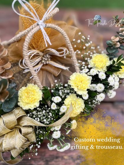 Custom wedding gifting and trousseau design that combines fresh yellow carnations with elegant gold ribbon work. This is a perfect example of how I use florals and textures to create a feeling of modern luxury.