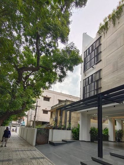 The street-level exterior of the RS head office building in Chennai. The design features a covered entrance, clean building lines, and large windows, presenting a modern and professional facade that integrates with the urban environment.