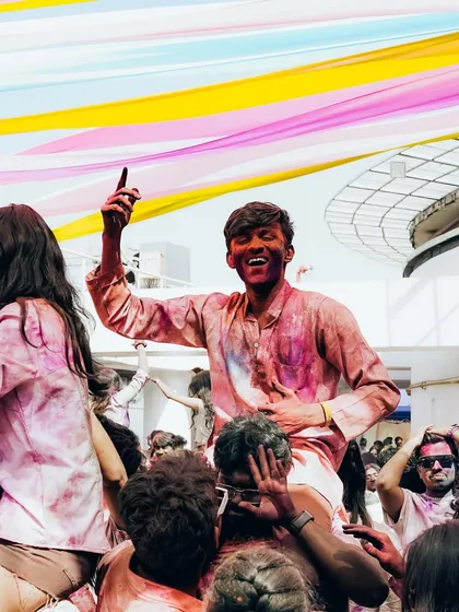 The pure joy of a rooftop Holi party in Bangalore. We capture these moments of celebration, with attendees dancing under a canopy of colorful decorations high above the city.