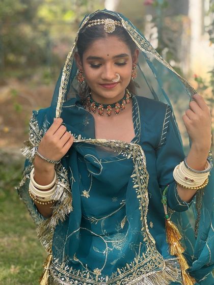 A traditional Rajasthani look, rich in color and detail. I created a classic look with defined eyes and a natural skin finish to complement the vibrant teal attire and authentic jewelry.