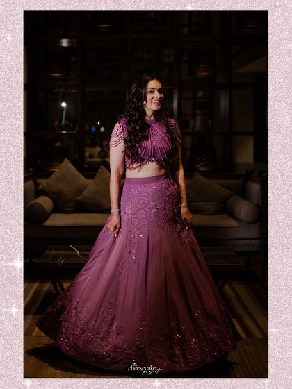 A beautiful full-length portrait of the bride in her gorgeous purple sangeet lehenga.