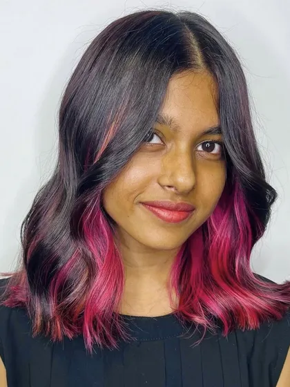 A pop of color can make all the difference. For this look, I added peekaboo pink highlights that frame the face and are revealed with movement. It's a playful way to experiment with vibrant shades without committing to an all-over color.