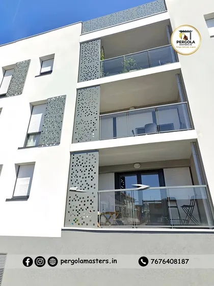 Perforated metal panels serve as both balcony dividers and decorative facade elements on this apartment building. The custom pattern adds a unique visual texture to the exterior while providing partial privacy for residents.