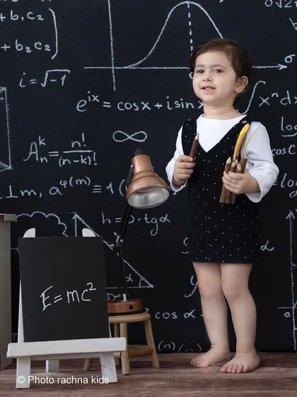 A standing portrait from the 'little professor' shoot, showing the full backdrop and props that create this academic setting.
