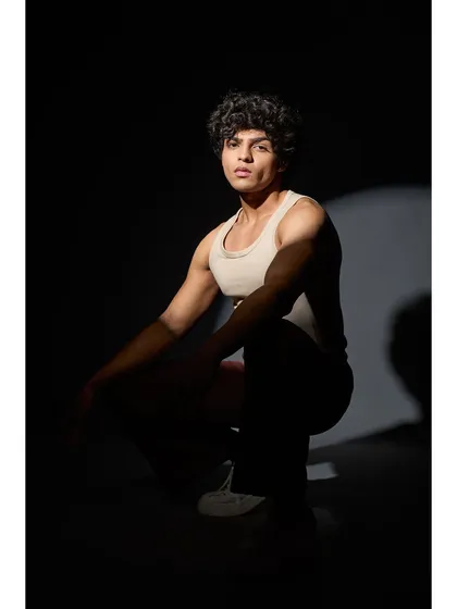 A dramatic, high-contrast portrait. The grooming is clean, but the lighting creates a moody, sculptural effect, highlighting his features.