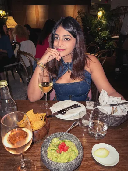A dinner setting in Dubai. The denim outfit is versatile enough for a chic dinner, paired with simple accessories.