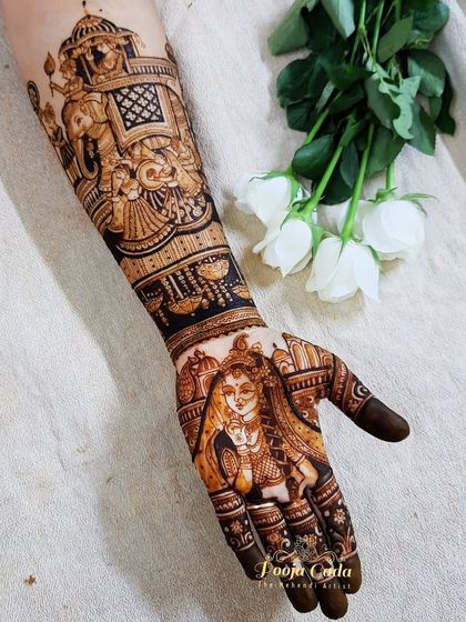 A stunning bridal design featuring a beautiful Radha portrait on the palm and a grand baraat scene on the forearm.