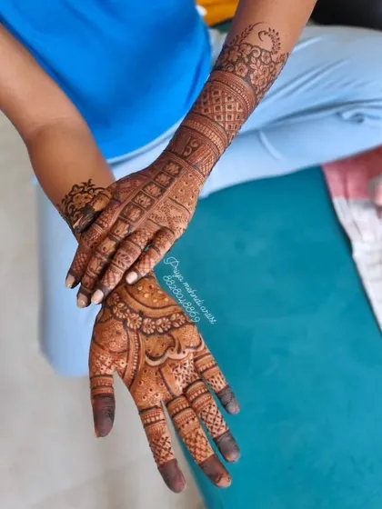 A classic and intricate bridal hand design. This pattern uses a mix of fine lines, bold shapes, and detailed checkerboard fills to create a timeless look that covers the hand and arm beautifully.