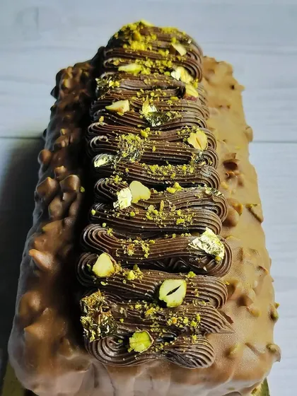 This is my Choco Pistachio Marble Pound Cake. It features swirls of chocolate and pistachio cake, covered in a milk chocolate glaze and topped with rich ganache and pistachios.