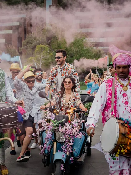 We believe your entry should be as unique as your story. For this couple, a vibrant procession on a floral-adorned scooter, complete with dhol players and colored smoke, created a fun, high-energy start to their celebration.