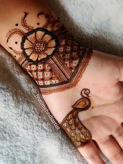 A creative and minimal design featuring a floral cuff at the wrist and a single peacock motif on the index finger.