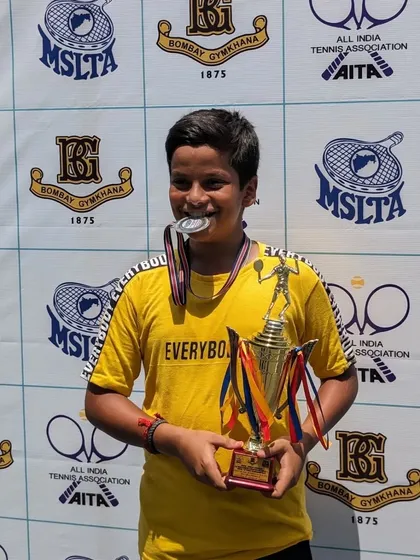 Abhinav Sharma biting his medal, a fun shot with his runner-up trophy.