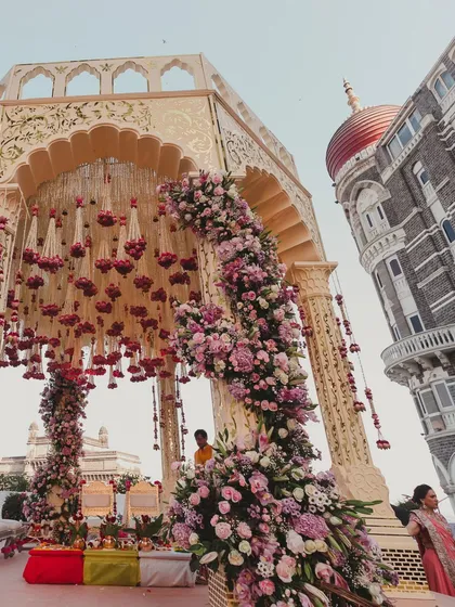 A stunning mandap at the Taj Mahal Palace in Mumbai, with the hotel's iconic dome in the background. We are experts at planning weddings in landmark city locations, blending urban energy with timeless elegance.