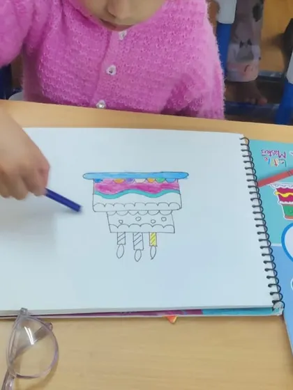 A student coloring a multi-layered cake. This is a fun way to practice using different colors and drawing patterns.