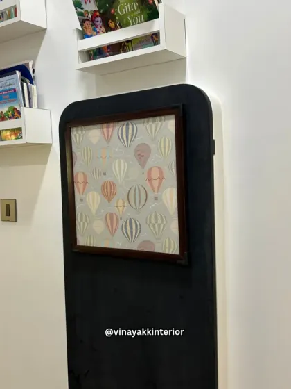 This image shows the thoughtful details that complete a kids' room, including wall-mounted bookshelves for easy access to stories and a framed picture with a playful hot air balloon pattern.