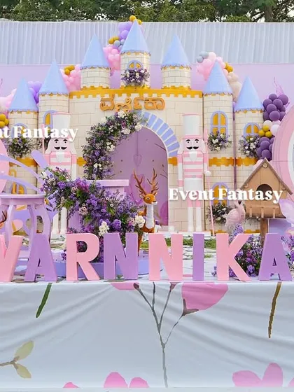 Another beautiful shot of Varnnika's fairyland stage, showcasing the complete setup with the castle, clock carriage, and personalized name blocks.