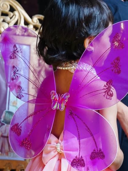 A close-up of a guest wearing her purple fairy wings. These little details help create a fully immersive themed experience.