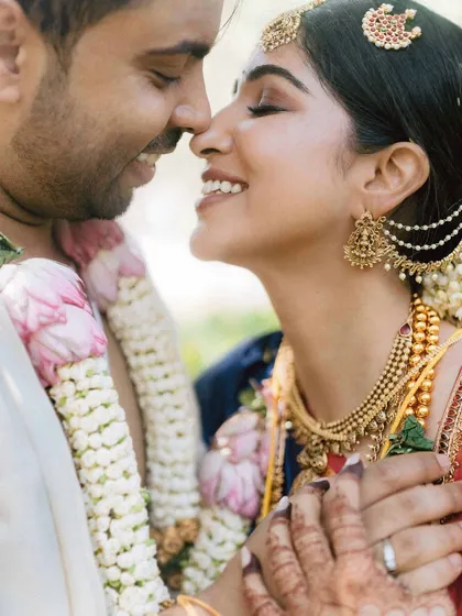 A tender moment from Venkai and Sruthi's South Indian wedding. The soft light, their close embrace, and genuine smiles create a portrait that is both intimate and beautiful, showcasing the warmth of their connection.