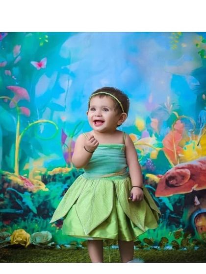 A Tinker Bell inspired dress for a magical photoshoot. The layered green petal skirt and simple bodice capture the playful spirit of the beloved fairy.