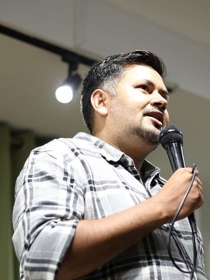 A comedian mid-performance, captured in a moment of connection with the crowd.