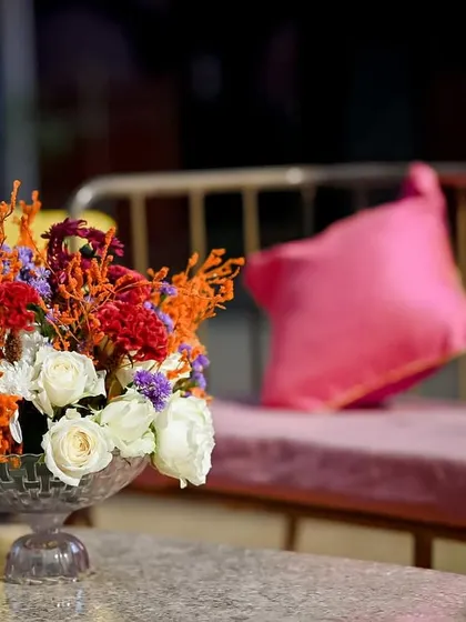 A beautiful floral centerpiece with a mix of vibrant and subtle colours, adding a touch of elegance to the casual seating.