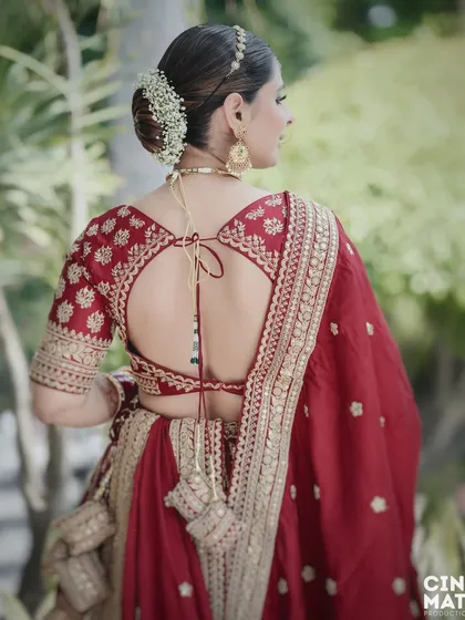 A focus on the details. This shot highlights the beautiful design of the bride's blouse and her elegant hairstyle adorned with flowers.