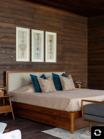 A prefabricated wooden bedroom suite featuring dark wood walls and a custom bed with an upholstered headboard. This design showcases our ability to create cozy, stylish sanctuaries using sustainable, factory-built components.