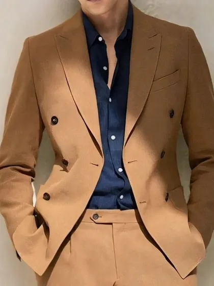 A tan double-breasted suit paired with a navy shirt. This is a sophisticated and modern color combination that we can create for you.
