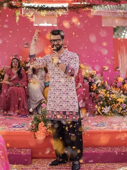 In the midst of a flower shower, still holding the mic and hyping the crowd. The show must go on, and so must the fun!