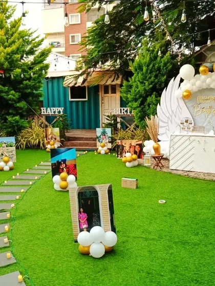 A personalized birthday walkway. I created a path lined with cherished photos on stands, leading guests to an elegant angel-wing backdrop, making the celebration deeply personal and touching.