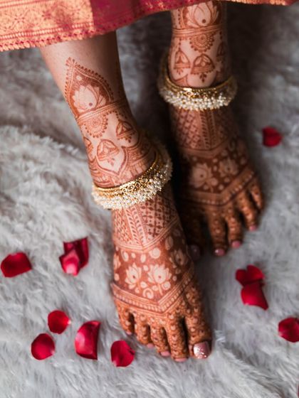 The bride's feet, adorned with beautiful mehendi and traditional pearl anklets. Every detail is part of the story.