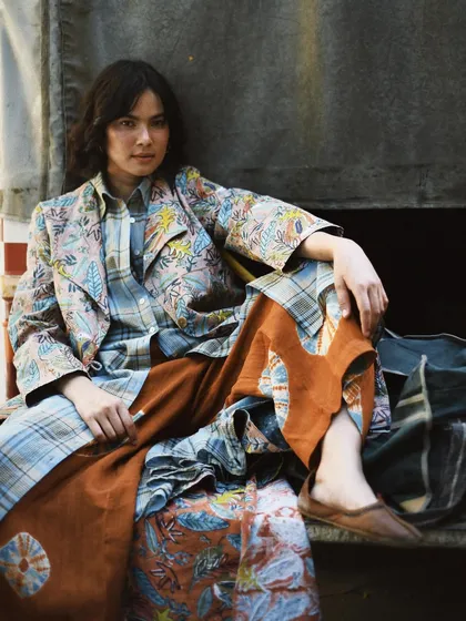 An urban-rustic setting for a layered, eclectic look. This shot proves that handmade, sustainable fashion has a place everywhere, from city streets to quiet corners.