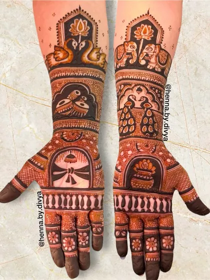 This beautiful full-arm mehendi was for the mother of the bride. It's filled with auspicious symbols like peacocks, elephants, swans, and a kalash (pot), celebrating her important role.