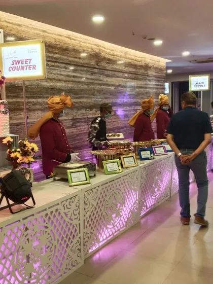 A closer look at our Rajasthani-themed sweet counter, showcasing the intricate design of the counter front and the traditional attire of our staff.