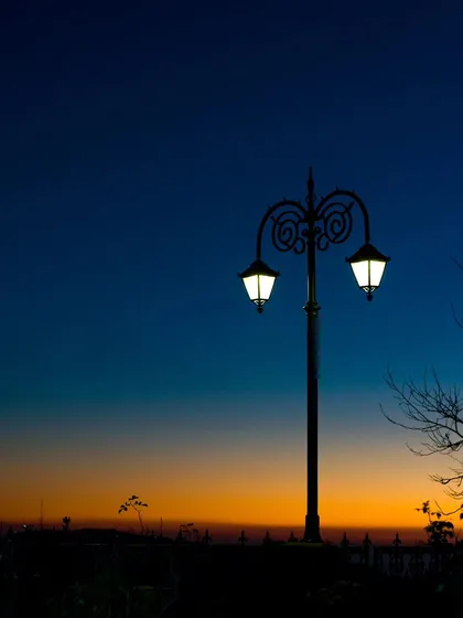A classic Victorian-style lamppost silhouetted against the twilight sky in Shimla.