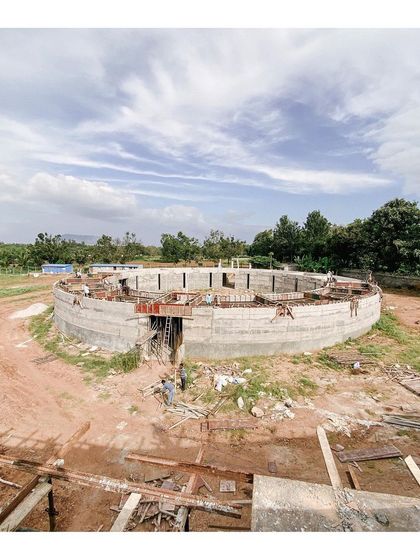 The memorabilia gallery structure during construction, with workers inside the circular form. This wide-angle shot captures the scale of the space and the quality of natural light from the open roof.
